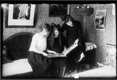 3 kvinnor sittande i rum med bok i händerna.
Nyckelord: Tavla Tapet