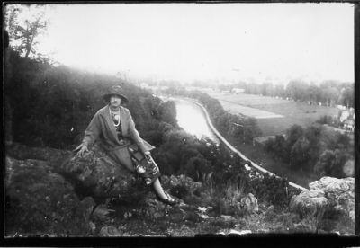 Kvinna sittande på berg med vattendrag i bakgrunden.
Nyckelord: Utsikt