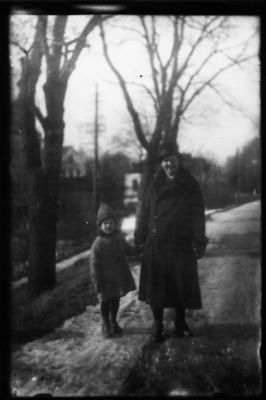 Kvinna och flicka stående på väg.
