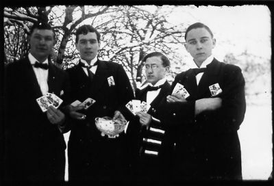 4 män stående med spelkort i händerna.
Nyckelord: Spelkort