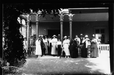 Ett antal personer stående på eller framför veranda.
Nyckelord: Veranda