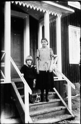 Kvinna och pojke stående på verandatrappa.
Nyckelord: Trappa Veranda