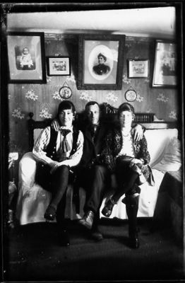 Man och 2 kvinnor sittande i rum.
Nyckelord: Tavla Tapet