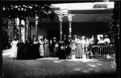 Ett antal personer stående på och framför veranda.
Nyckelord: Veranda