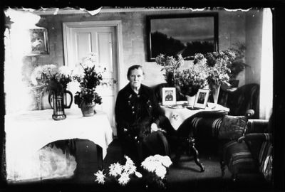 Kvinna sittande i rum med blommor.
Nyckelord: Blommor Tavla