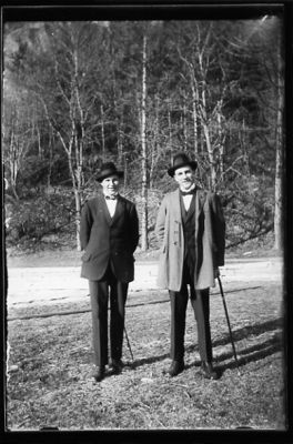 2 män stående på gräsmatta.
Nyckelord: Käpp