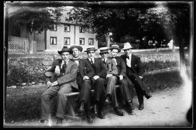 6 män sittande på parkbänk framför vattendrag.
Nyckelord: Parkbänk