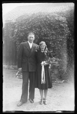 Man och kvinna stående framför byggnad.
