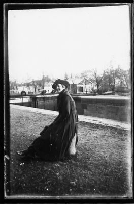 Kvinna sittande på pollare intill sluss.
Nyckelord: Sluss Pollare