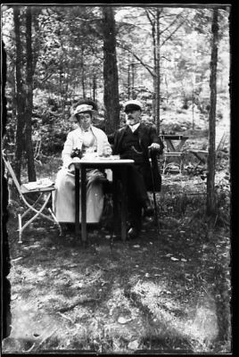 Man och kvinna sittande vid kaffebord i skogsbacke.
Nyckelord: Trädgårdsmöbel Kaffe Käpp