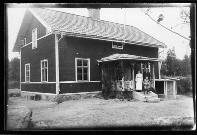 Man, kvinna och pojke stående på verandatrappa.
Nyckelord: Veranda