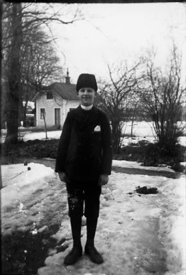 Pojke stående på gång.
Nyckelord: Vinter