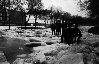 Ett antal personer stående eller sittande på isflak.
Nyckelord: Islossning Vinter Isflak