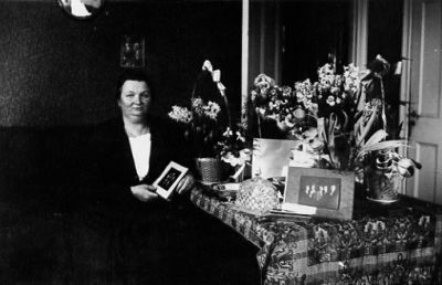 Kvinna sittande i rum.
Nyckelord: Födelsedag Blommor Presentbord