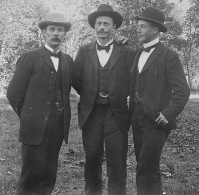 3 män stående i naturen
