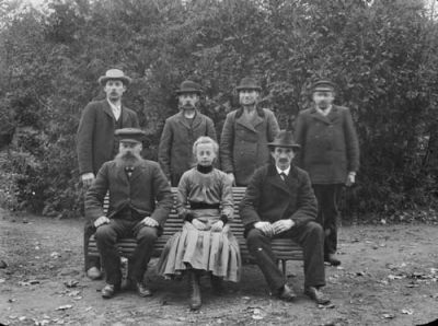 4 stående män, 2 sittande män och en kvinna
