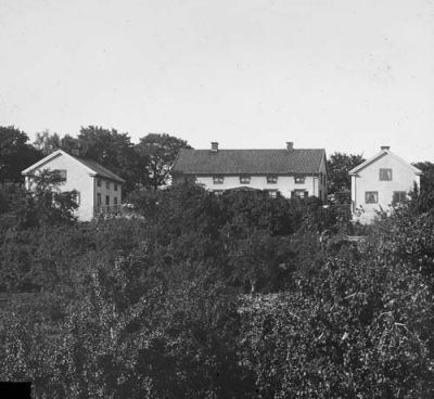 Huvudbyggnad med flygelbyggnader på kulle
