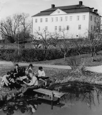 Ungdomar vid brygga framför slott
