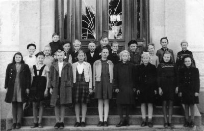 Folkskoleklass framför skolbyggnaden
