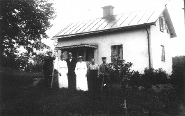 4 män och 2 kvinnor stående framför byggnad.
Nyckelord: Trädgård Veranda Lie