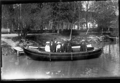 5 män och 2 kvinnor stående i båt.
Nyckelord: Dräkt