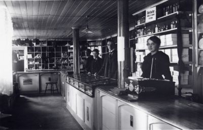 3 män och 1 kvinna stående bakom disken i affär.
Nyckelord: Affärsinredning