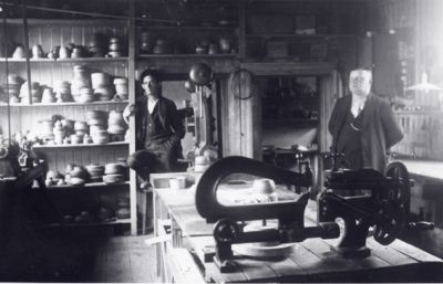 2 män stående i verkstad.
