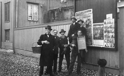 6 män stående framför byggnad.
Nyckelord: Kullersten