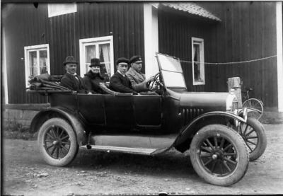 3 män och 1 kvinna sittande i bil.
Nyckelord: Bil