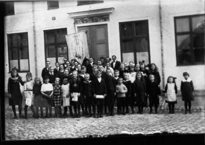 Ett antal personer stående framför byggnad.
Nyckelord: Kullersten