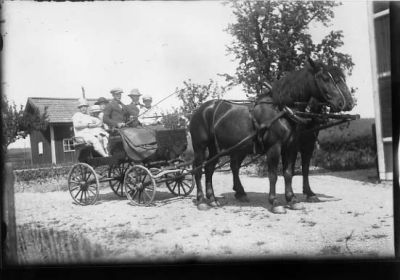 6 personer sittande i hästekipage.
Nyckelord: Häst Vagn