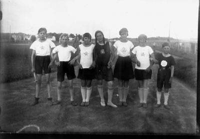 7 ungdomar stående på idrottsplats.
Nyckelord: Tävlingsdress