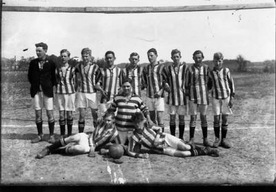 12 ungdomar framför fotbollsmål.
