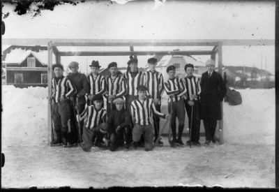 12 män stående framför bandymål.
Nyckelord: Målställning Vinter