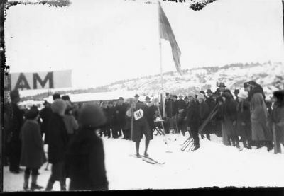 Ett antal personer stående vid skidtävling.
Nyckelord: Skidtävling Folksamling Vinter