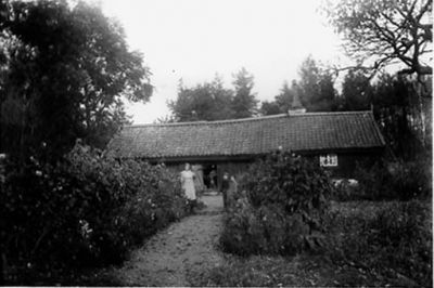 Ett antal personer framför byggnad.

