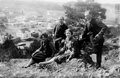 2 stående män och 2 sittande kvinnor på berg med bebyggelse i bakgrunden.
Nyckelord: Utsikt