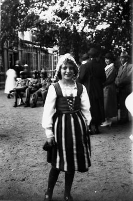 Flicka stående i park.
Nyckelord: Dräkt