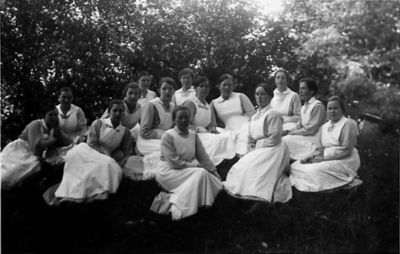 Ett antal kvinnor sittande i skogsbacke.
Nyckelord: Skogsbacke Dräkt