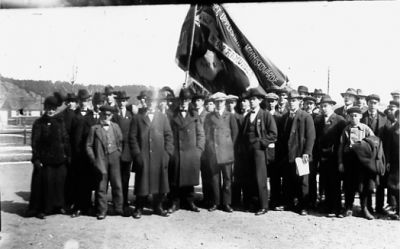 Ett antal personer stående med flagga.
