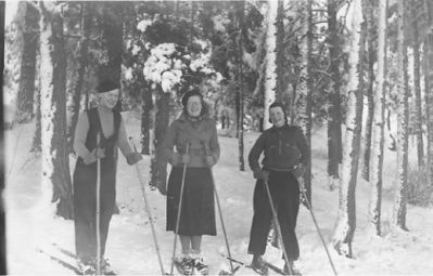 3 kvinnor på skidor.
Nyckelord: Dräkt Vinter