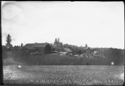 Gärde med lantgård i bakgrunden.
