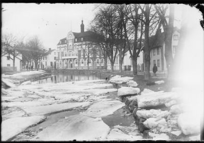 Vattendrag med byggnader i bakgrunden.
Nyckelord: Vinter