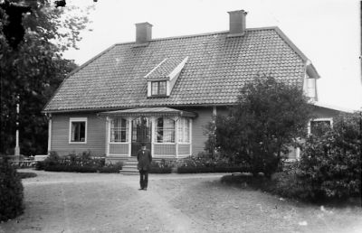 Man stående framför byggnad.
Nyckelord: Veranda