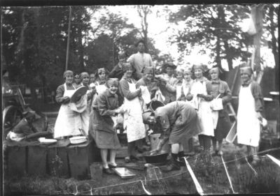 Ett antal män och kvinnor stående i fältkök.
Nyckelord: Uniform Kokkärl Diskbalja