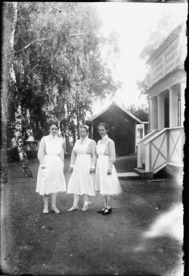 3 kvinnor i uniform stående framför byggnad.
Nyckelord: Gårdsplan Byggnad Uniform