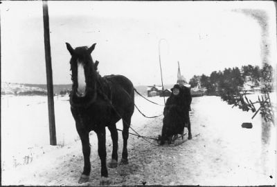 Kvinna sittande och kvinna stående på spark, dragen av häst.
Nyckelord: Häst Spark Vinter