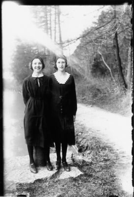 2 flickor stående intill väg.
Nyckelord: Väg Träd