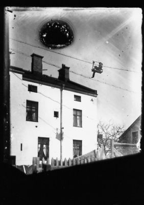 Man sittande i någon form av linbana.
Nyckelord: Staket