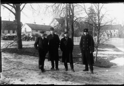 4 män, varav 1 i polisuniform stående i park.
Nyckelord: Uniform